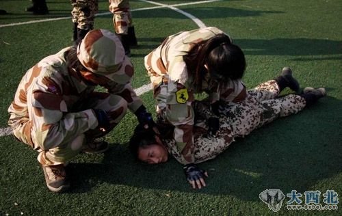 1月13日,训练员(左一)在教女保镖如何缴械。(路透社)