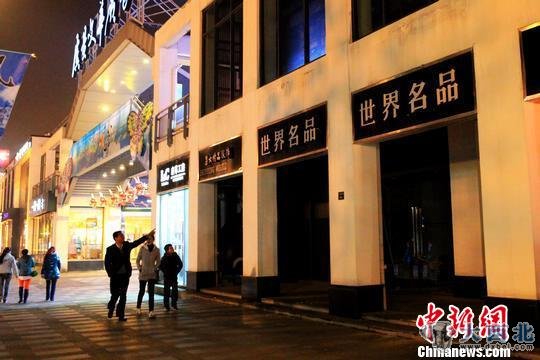 散步路过常熟市民在指点已关门的“世界名品店”。 李克祥 摄
