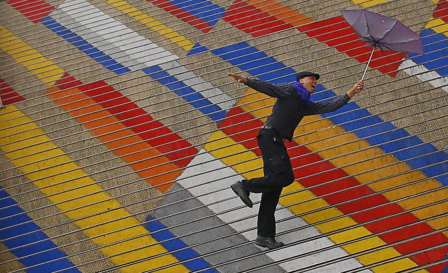 9月19日,奥地利维也纳,一名加拿大游客手拿雨伞在阿尔贝蒂纳博物馆的彩色台阶上。 AFP PHOTO / ALEXANDER KLEIN