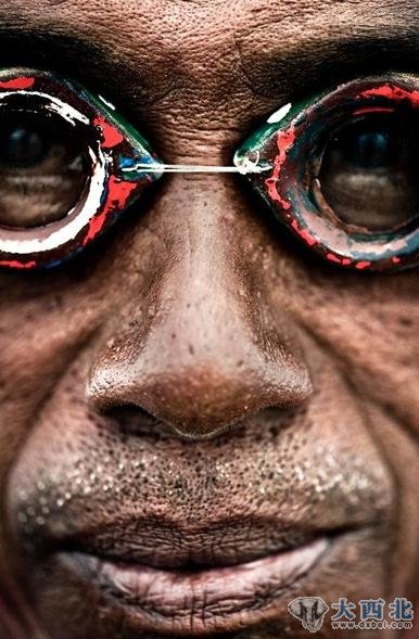 兰克的面部特写。轮胎棒的重量允许他留在海底,沿着珊瑚礁移动。为了平衡深潜时内耳和外耳的压力,巴瑶族人很小的时候就故意刺破耳膜。这种做法导致他们年老时出现耳聋。