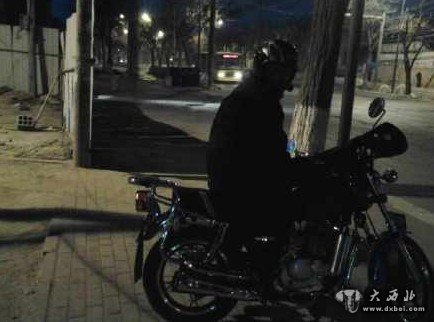 初三早晨7时许天还没亮,兰州西站一位摩托司机就在路边候客。