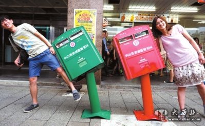 ▲台风过后,市民与被刮歪的邮箱合影。 图/东方IC