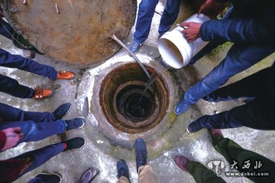 干涸的水井下坑洞暗藏,倒水进去,水很快渗透到地底。