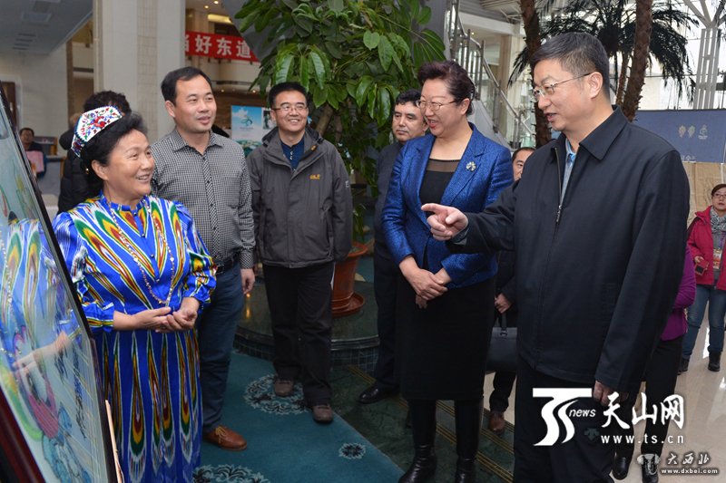 十三冬组委会副主任、自治区党委常委、宣传部部长李学军,十三冬组委会副主任、自治区副主席田文参观哈密群众代表伊萨来提·达吾提向组委会赠送刺绣作品《新疆欢迎您》。